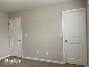 Lowell house for rent - a bedroom with two white doors and a carpeted floor