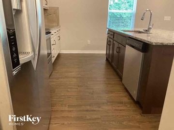 Lowell house for rent - a kitchen with wooden floors and stainless steel appliances