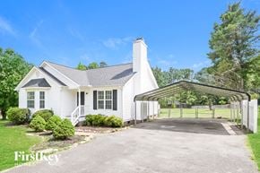Willow Spring house for rent - A white house with a black roof and a garage door.