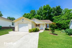 High Point house for rent - a white and yellow house with a white garage door