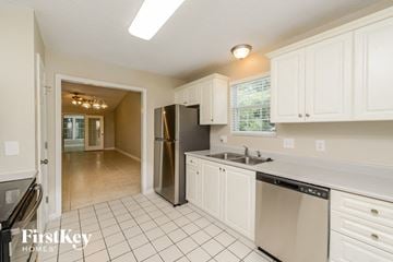 High Point house for rent - a kitchen with white cabinets and a sink and a refrigerator