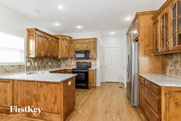 Kansas City house for rent - A kitchen with wooden cabinets and a refrigerator.