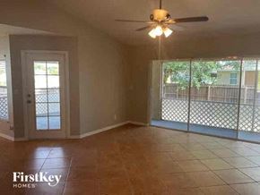 Cape Coral house for rent - an empty living room with a ceiling fan and a glass door
