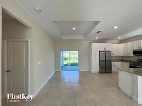 Cape Coral house for rent - a large empty kitchen with a refrigerator and a sink