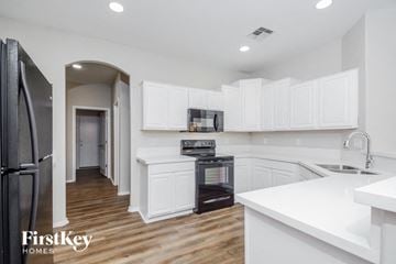 Avondale house for rent - A kitchen with white cabinets and a black oven.