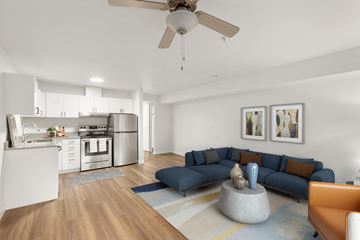 Bellevue apartment for rent - a living room with a blue couch and a kitchen in the background