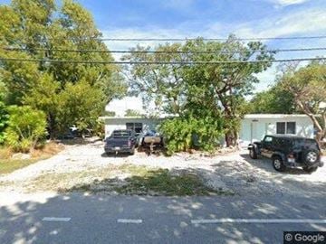 Tavernier apartment for rent - A gravel driveway leads to a house with a black car parked in front.