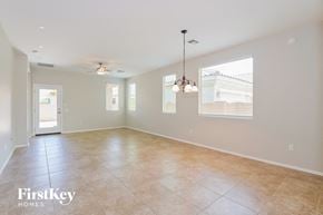 Tucson house for rent - A spacious room with a ceiling fan and a chandelier.
