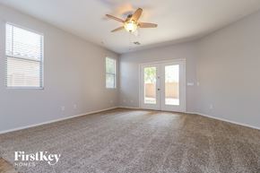 Surprise house for rent - A spacious room with a ceiling fan and carpeted floor.