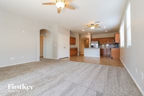 Surprise house for rent - A spacious living room with a carpeted floor and a ceiling fan.