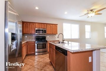 Surprise house for rent - A kitchen with wooden cabinets and a refrigerator.