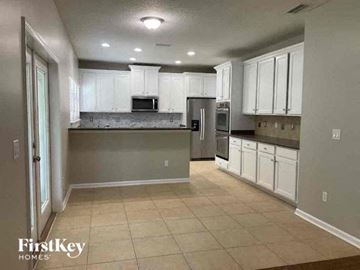 Fleming Island house for rent - a large kitchen with white cabinets and stainless steel appliances