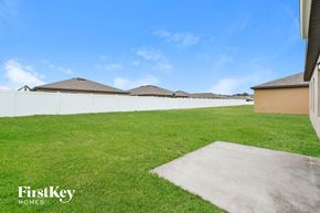 Winter Haven house for rent - A grassy area with a concrete slab in the foreground and houses in the background.