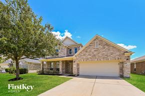 Katy house for rent - A house with a garage and a tree in front of it.