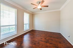 Katy house for rent - A room with a ceiling fan and wooden flooring.