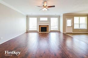 Katy house for rent - A spacious room with wooden floors and a fireplace.