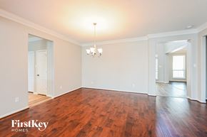 Katy house for rent - A large empty room with wooden floors and a chandelier.