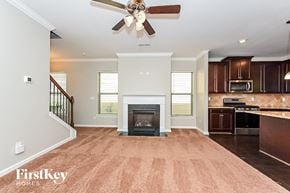 Mcdonough house for rent - a kitchen with a living room with a fireplace and a ceiling fan