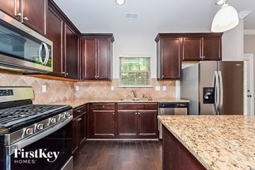 Mcdonough house for rent - a kitchen with wood cabinets and granite counter tops and stainless steel appliances