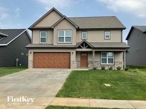 Clarksville house for rent - a house with a garage door and a lawn