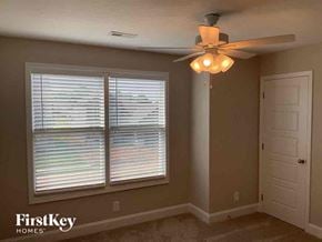 Clarksville house for rent - a living room with a ceiling fan and a window