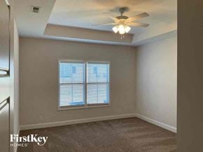 Clarksville house for rent - an empty bedroom with a ceiling fan and a window