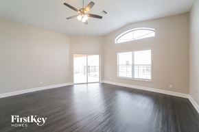Riverview house for rent - A spacious room with a ceiling fan and sliding glass doors.