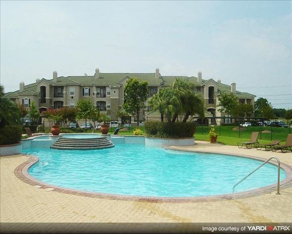 Houston apartment for rent - a swimming pool with an apartment building in the background