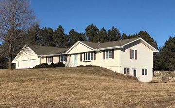 Hickman house for rent - a white house with a hill in front of it