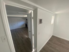 Vista apartment for rent - A room with white walls and wooden flooring with a doorway leading to another room.