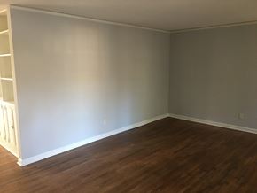Atlanta house for rent - an empty living room with wooden floors and grey walls