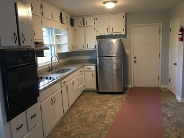 Atlanta house for rent - an empty kitchen with white cabinets and stainless steel appliances