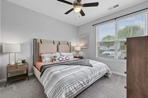 Mooresville apartment for rent - A bedroom with a large bed and a ceiling fan.