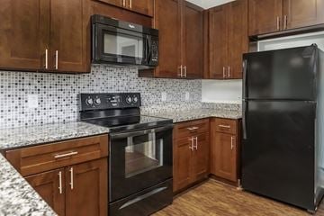 Nashville apartment for rent - A kitchen with black appliances and brown cabinets.