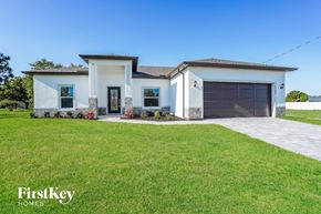 Cape Coral house for rent - a house with a lawn and a driveway and a garage door