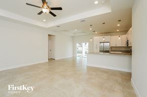Cape Coral house for rent - an empty kitchen and living room with a ceiling fan