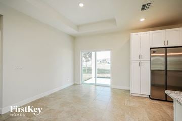Cape Coral house for rent - a large kitchen with stainless steel appliances and white cabinets