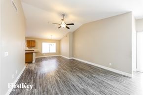 Surprise house for rent - A spacious room with a ceiling fan and wooden flooring.