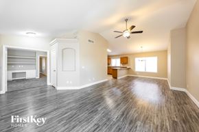 Surprise house for rent - A spacious room with wood flooring and a ceiling fan.