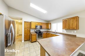 Surprise house for rent - A kitchen with wooden cabinets and a refrigerator.