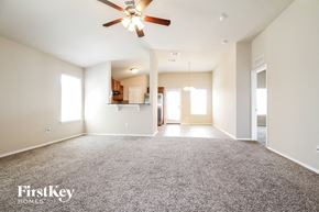 Edmond house for rent - an empty living room with a ceiling fan and carpet