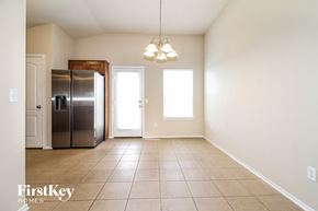Edmond house for rent - an empty dining room with a refrigerator and a door to the kitchen