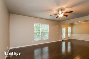 Lawrenceville house for rent - A spacious room with a ceiling fan and wooden flooring.