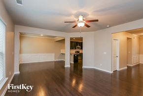 Lawrenceville house for rent - A spacious living room with a ceiling fan and hardwood floors.