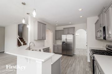 Gastonia house for rent - a white kitchen with stainless steel appliances and white counter tops