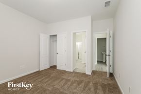 Gastonia house for rent - a bedroom with white walls and white doors and a carpeted floor