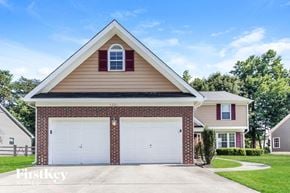 Charlotte house for rent - a brick house with two garage doors on a lawn