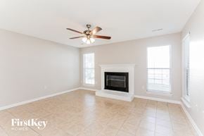 Charlotte house for rent - a living room with a fireplace and a ceiling fan