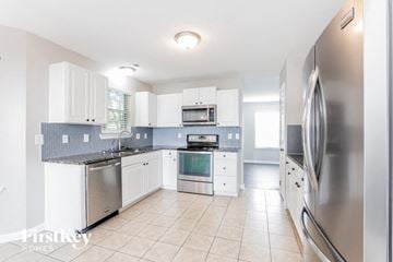 Charlotte house for rent - a large kitchen with stainless steel appliances and white cabinets