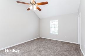 Charlotte house for rent - a bedroom with a ceiling fan and a carpet